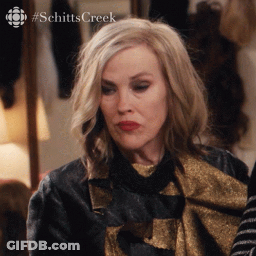 A Close Up Of A Woman 'S Face With The Hashtag Schitts Creek Visible GIF