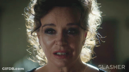A Close Up Of A Woman 'S Face With The Word Slasher Behind Her GIF