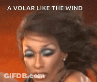 A Close Up Of A Woman 'S Face With The Words `` A Volar Like The Wind '' Behind Her . GIF