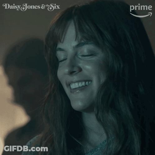 A Close Up Of A Woman 'S Face With The Words Daisy Jones & The Six On The Bottom GIF