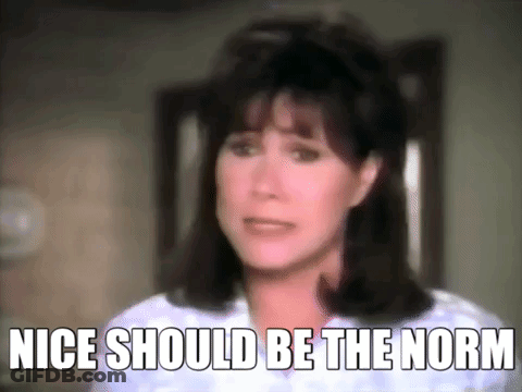 A Close Up Of A Woman 'S Face With The Words " Nice Should Be The Norm " Written Below Her . GIF