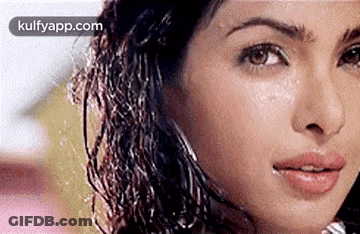 A Close Up Of A Woman 'S Face With Water Drops On Her Face . GIF