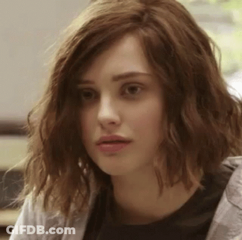 A Close Up Of A Woman 'S Face With Wavy Hair And A Black Shirt . GIF