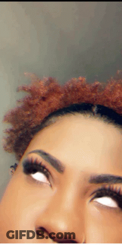 A Close Up Of A Woman 'S Face With White Eyes And Red Hair GIF