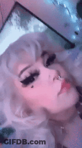 A Close Up Of A Woman 'S Face With White Hair And A Nose Ring GIF