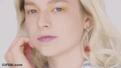 A Close Up Of A Woman 'S Face With Yellow Eye Shadow On . GIF