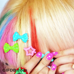 A Close Up Of A Woman 'S Hair With Colorful Hair Clips GIF