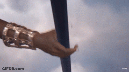 A Close Up Of A Woman 'S Hand Holding A Pole With A Blue Sky In The Background GIF