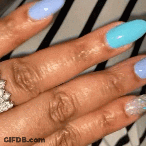 A Close Up Of A Woman 'S Hand With Long Nails And A Ring On Her Finger . GIF