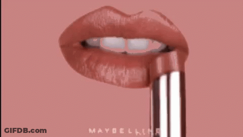 A Close Up Of A Woman 'S Lips With A Maybelline Lipstick Sticking Out Of Them . GIF
