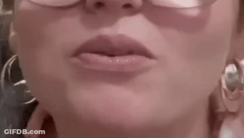 A Close Up Of A Woman 'S Lips With Glasses And Hoop Earrings . GIF