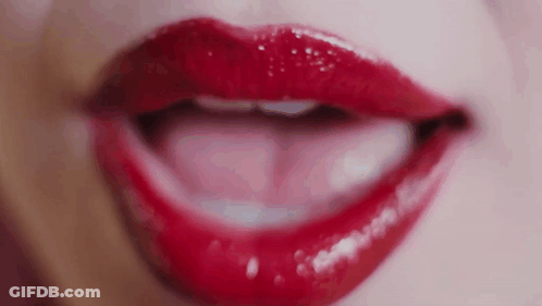 A Close Up Of A Woman 'S Lips With Red Lipstick On Them . GIF