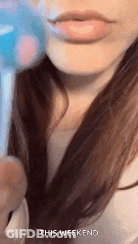 A Close Up Of A Woman 'S Lips With The Words `` This Weekend '' Written Above Her . GIF