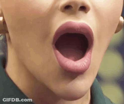 A Close Up Of A Woman 'S Mouth With Her Mouth Open And Her Tongue Sticking Out . GIF