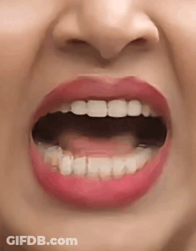 A Close Up Of A Woman 'S Mouth With Her Mouth Open And Red Lips . GIF