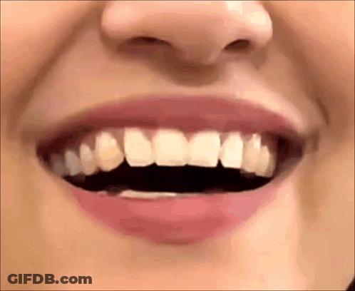 A Close Up Of A Woman 'S Mouth With Her Teeth Visible . GIF