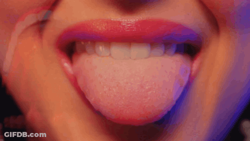 A Close Up Of A Woman 'S Mouth With Her Tongue Out GIF