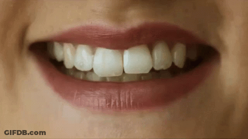 A Close Up Of A Woman 'S Mouth With Red Lips And White Teeth GIF