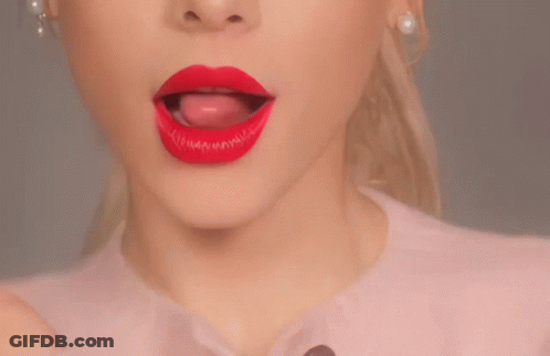 A Close Up Of A Woman 'S Mouth With Red Lipstick And Her Tongue Sticking Out GIF