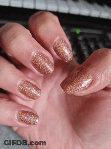 A Close Up Of A Woman 'S Nails With A Green Light On The Keyboard In The Background GIF
