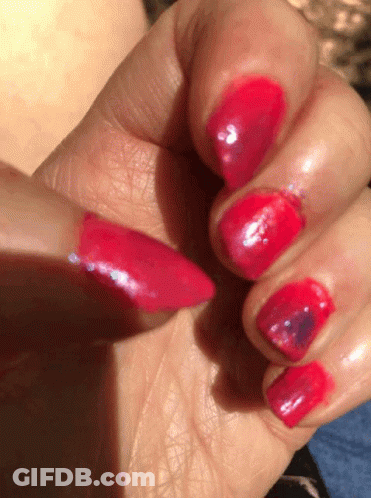 A Close Up Of A Woman 'S Nails With Red Polish On Them GIF