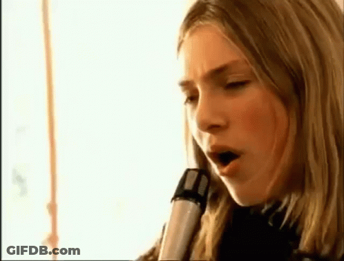 A Close Up Of A Woman Singing Into A Microphone GIF