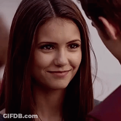 A Close Up Of A Woman Smiling At A Man While Looking At Him . GIF