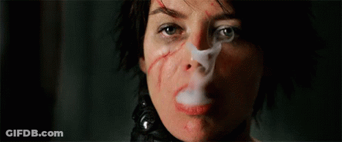 A Close Up Of A Woman Smoking A Cigarette With A Bandage On Her Face . GIF