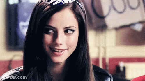 A Close Up Of A Woman Wearing A Bandana On Her Head And Smiling . GIF