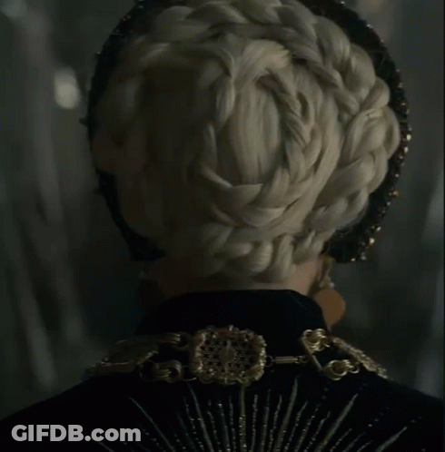 A Close Up Of A Woman Wearing A Black And Gold Outfit GIF