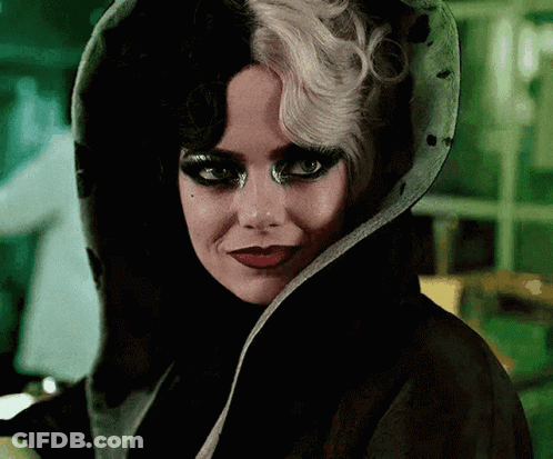 A Close Up Of A Woman Wearing A Black And White Wig And A Black Coat . GIF