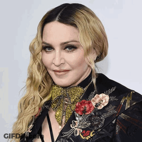 A Close Up Of A Woman Wearing A Black Jacket With Flowers On It GIF