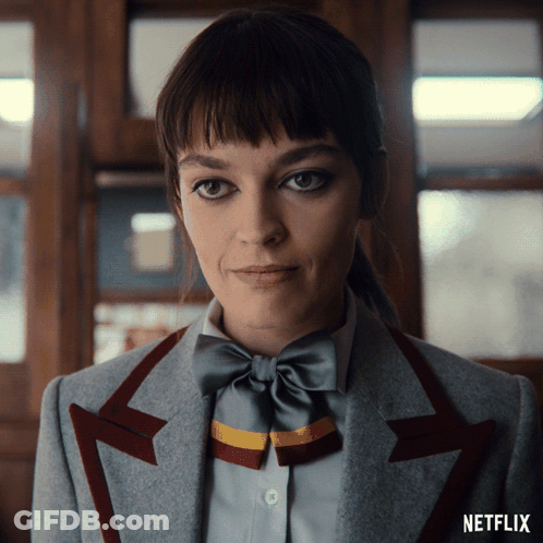 A Close Up Of A Woman Wearing A Bow Tie And A Netflix Logo On The Bottom GIF