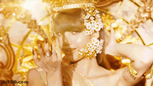 A Close Up Of A Woman Wearing A Crown And Earrings With Flowers On Her Face . GIF