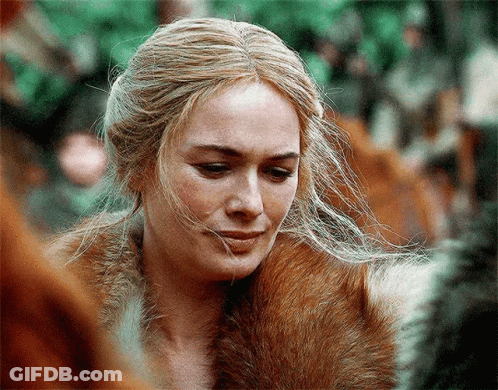 A Close Up Of A Woman Wearing A Fur Coat And Looking Down GIF