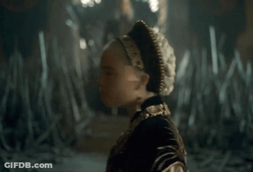 A Close Up Of A Woman Wearing A Gold Necklace And Earrings GIF
