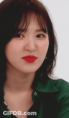A Close Up Of A Woman Wearing A Green Shirt With Red Lipstick GIF
