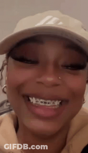 A Close Up Of A Woman Wearing A Hat And Smiling . GIF