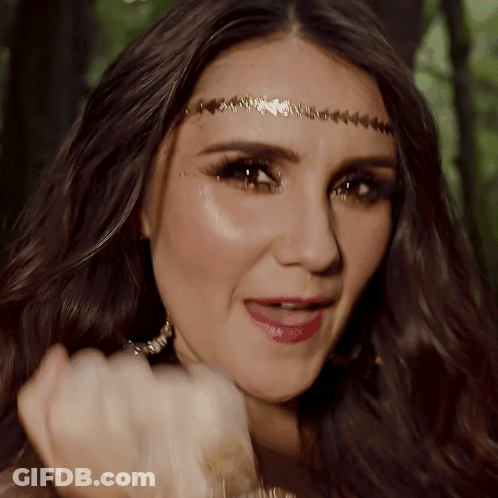 A Close Up Of A Woman Wearing A Headband And Earrings GIF