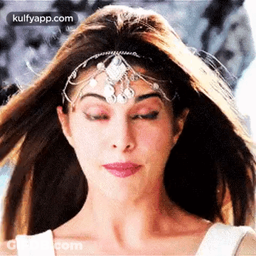 A Close Up Of A Woman Wearing A Headpiece And Making A Funny Face . GIF