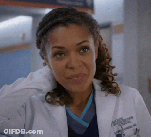 A Close Up Of A Woman Wearing A Lab Coat And Scrubs GIF