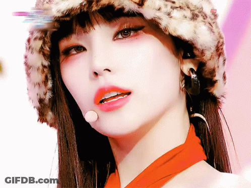 A Close Up Of A Woman Wearing A Leopard Print Hat And Scarf GIF
