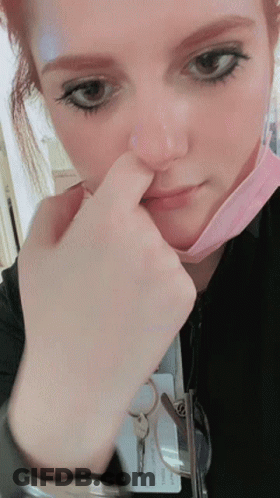 A Close Up Of A Woman Wearing A Mask And A Name Tag That Says ' Chris ' On It GIF