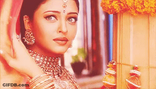A Close Up Of A Woman Wearing A Necklace And Earrings Standing Next To A Window . GIF