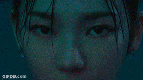 A Close Up Of A Woman Wearing A Necklace That Says ' N ' On It GIF