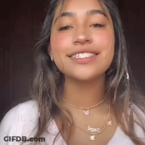 A Close Up Of A Woman Wearing A Necklace With A Butterfly Pendant . GIF