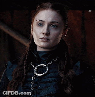 A Close Up Of A Woman Wearing A Necklace With A Chain Around Her Neck GIF