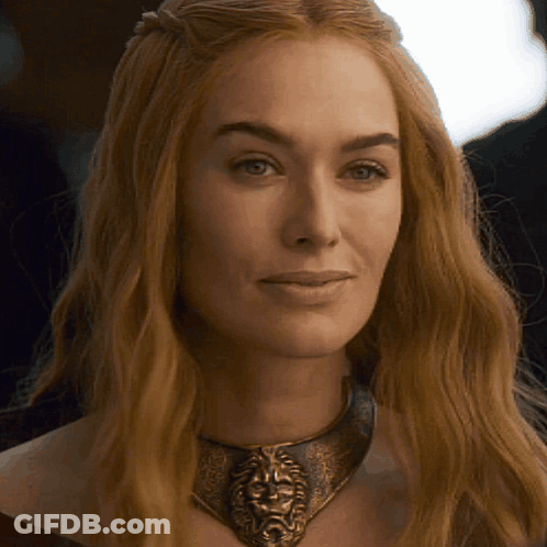 A Close Up Of A Woman Wearing A Necklace With A Lion Face On It GIF