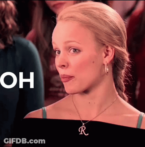 A Close Up Of A Woman Wearing A Necklace With The Letter R On It GIF