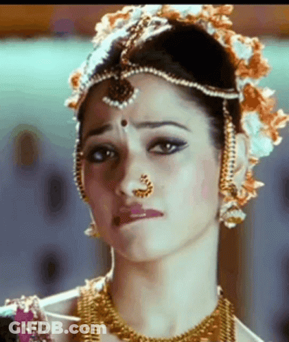 A Close Up Of A Woman Wearing A Nose Ring And A Headpiece . GIF